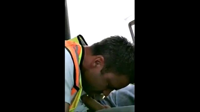 A worker in a reflective jacket sucks himself in his work car