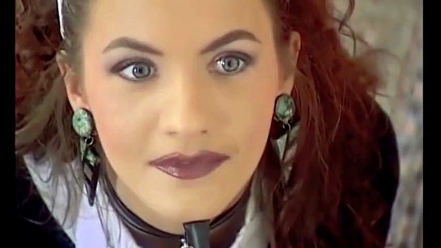 Une maîtresse bottée met une esclave dans des cuissardes rouges.