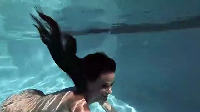 Brunette MILF Sofie Marie dives into the pool to play with a dildo