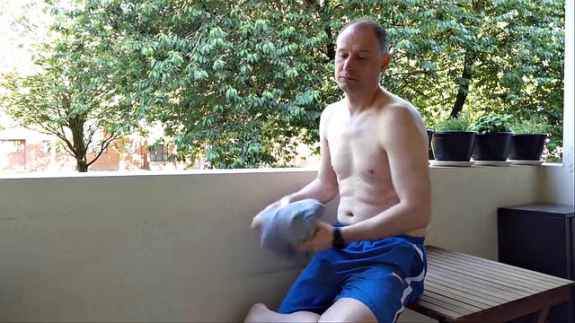 Man undressing outside on the balcony naked, he jerks his semi-erect shaved cock which stands erect and gets dressed again